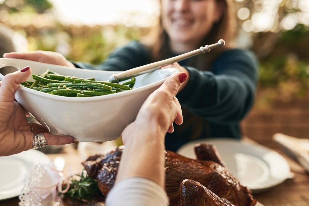 Woman passing dish at table