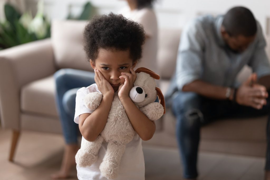 Lonely boy embraces soft toy as symbol seeking for protection support, son closed ears not to hear parents scandal.